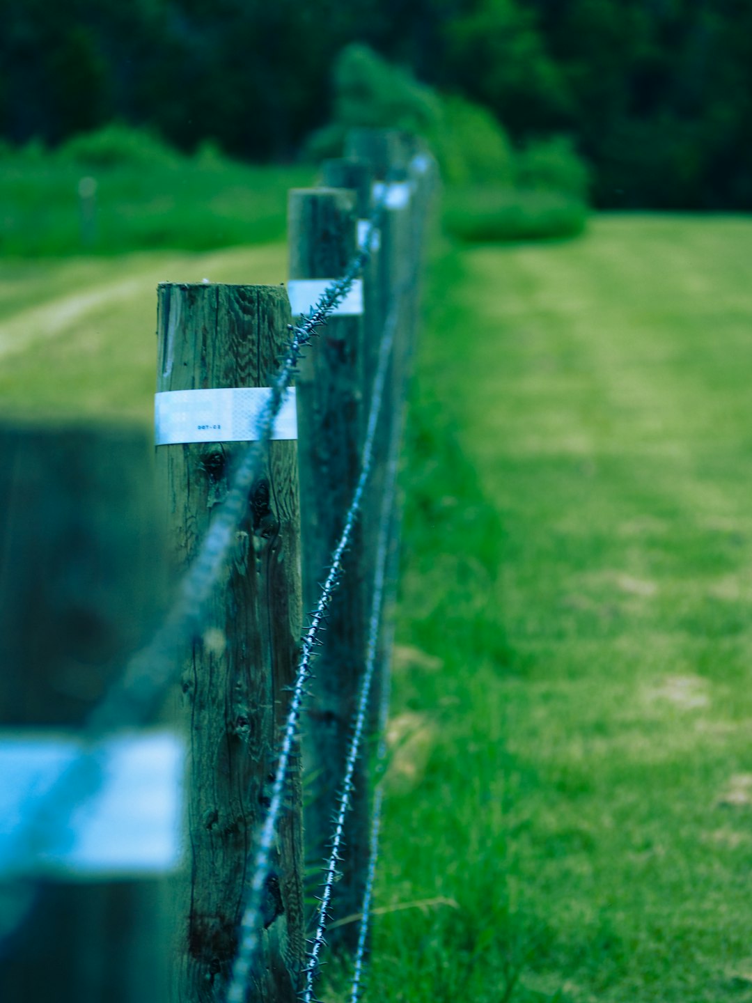 A wood chain fence in a field.